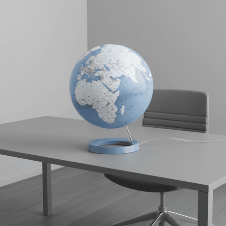 Illuminated Blue Light & Color globe on a sleek grey desk in a modern office.