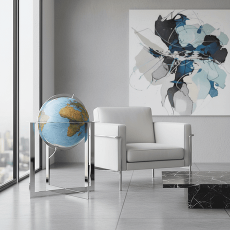 Waypoint Maranello 20-inch globe standing next to a modern low-profile leather armchair in an executive lounge.