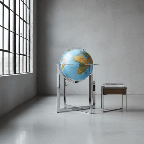 Maranello globe with silver stand placed against a concrete wall in a modern loft.