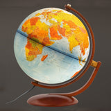 Gibraltar globe illuminated in dark room showing physical earth details and wood meridian